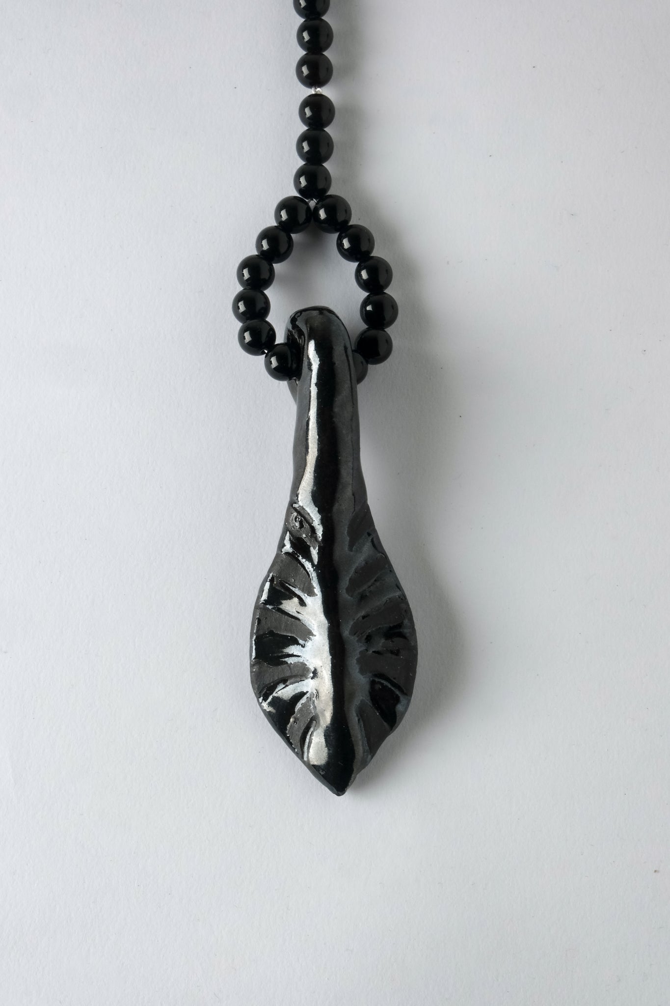 1/1 – Glazed Black Leaf Pendant on Onyx and Quartz Beaded Cord